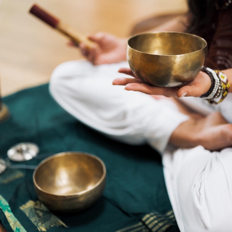 person sitting with Tibetan singing bowls